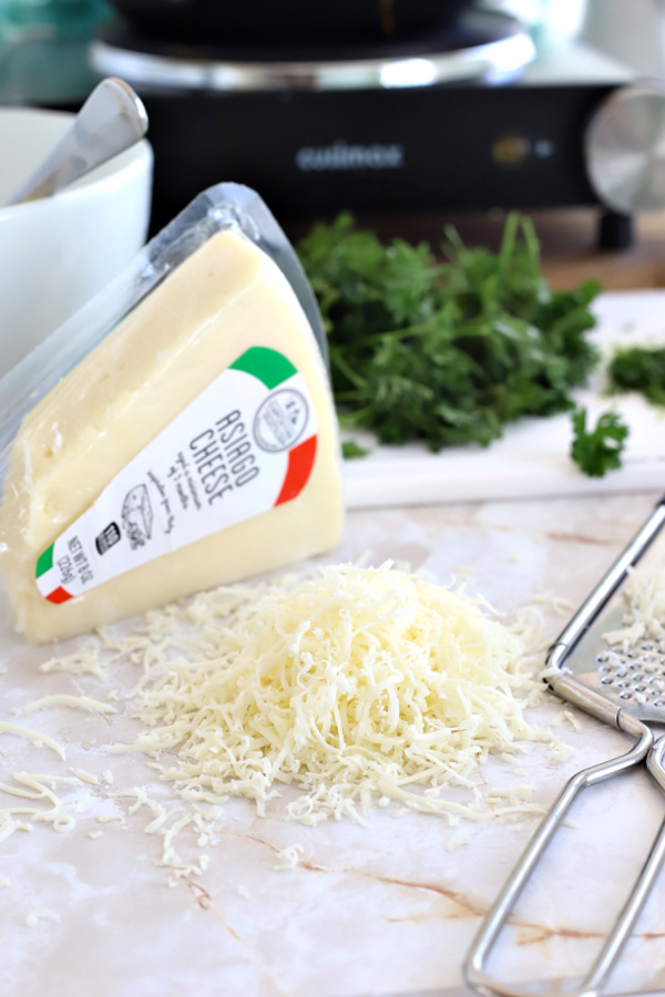 Shredding Asiago cheese for homemade manicotti.