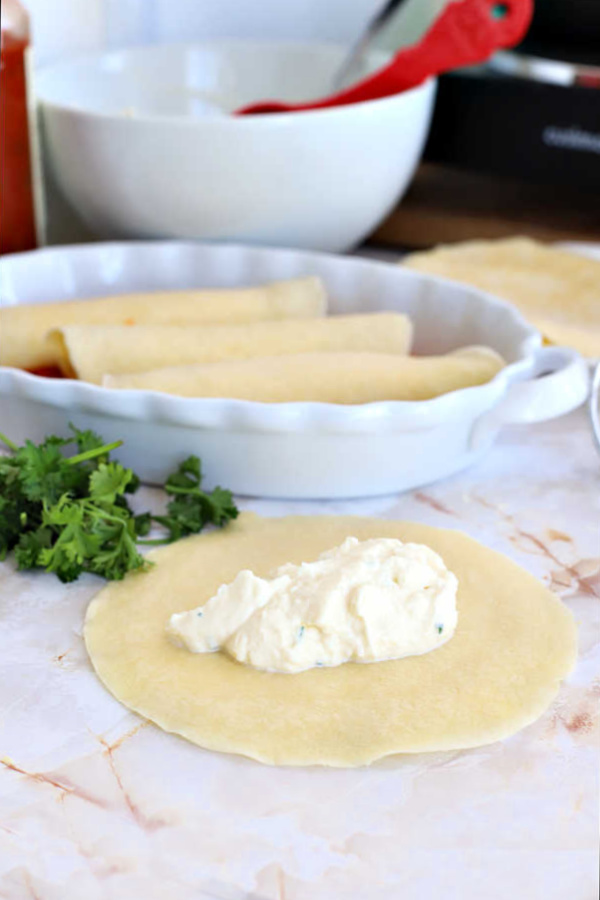 Filling homemade crepes with cheese mixture for manicotti.