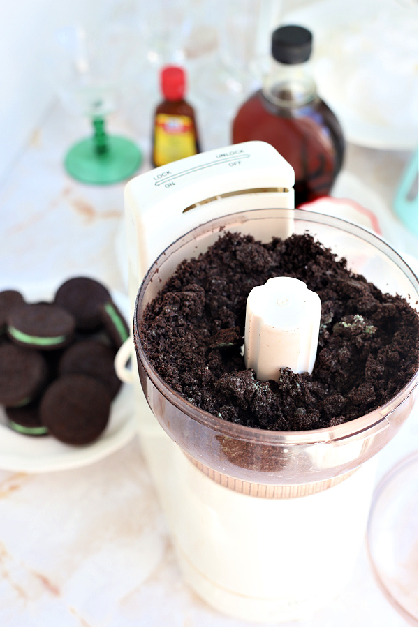 Mini food processor making crumbs from minty Oreo cookies for minty chocolate cheesecake parfait desserts cups.
