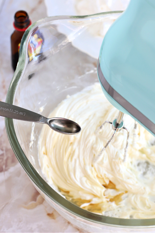 Adding mint extract to cream cheese for making Chocolate Mint Cheesecake Parfait.