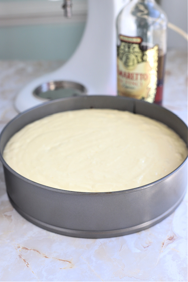Pouring the cream cheese batter into prepared springform pan for NY style cheesecake recipe.