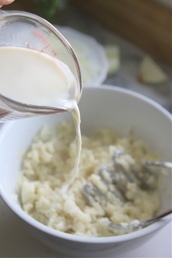 Adding milk for mashing potatoes.