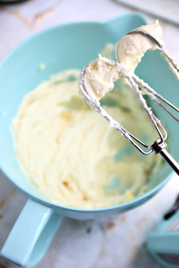 Creaming together butter and cream cheese for lemon sheet cake frosting.
