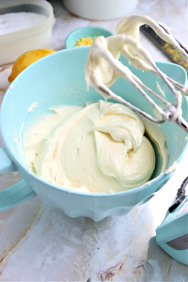 Creaming together butter and cream cheese for lemon sheet cake frosting.