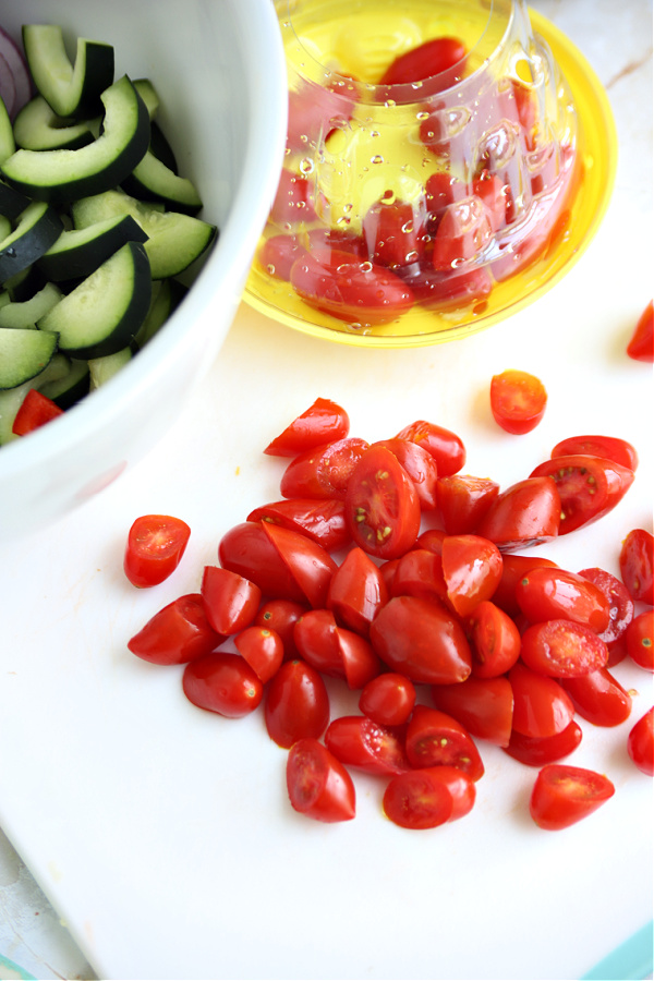 Cutting cherry tomatoes for Greek panzanella salad.