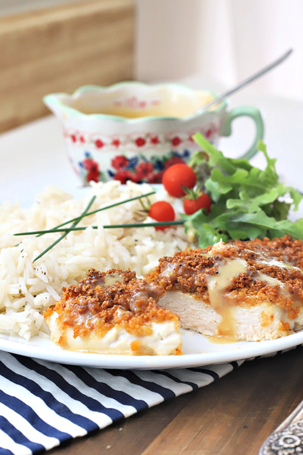 Juicy chicken breasts with a crispy Parmesan and panko coating is oven baked rather than fried. Easy recipe for Parmesan crusted chicken with honey mustard.